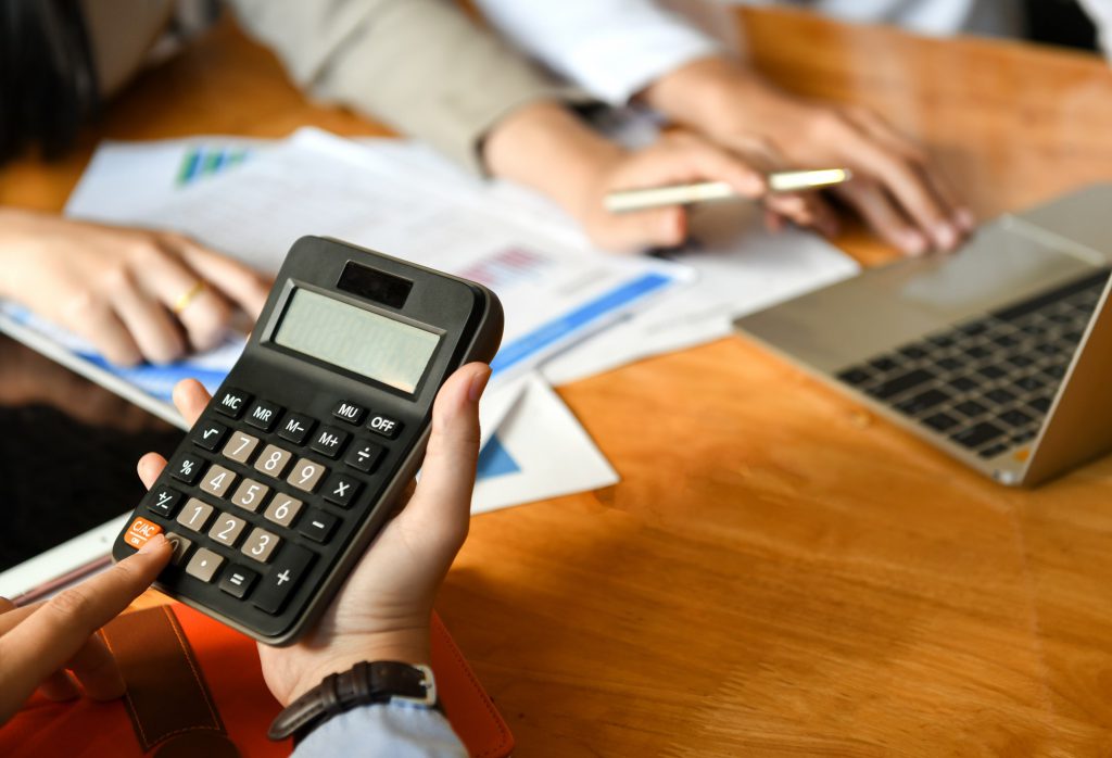 The accounting team is using the calculator in the office.